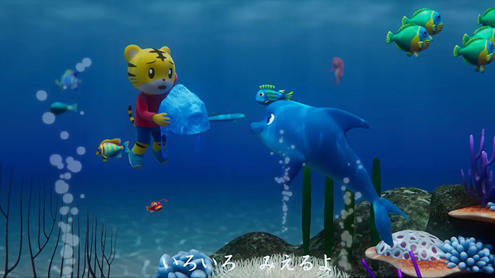 しまじろうが海中でイルカと向き合っている